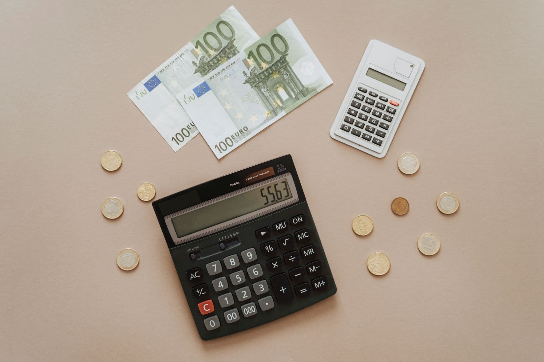 Rekenmachine en eurogeld voor het berekenen van de maandelijkse VvE-bijdrage